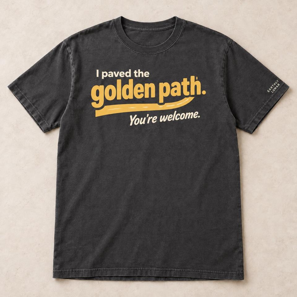 Charcoal tee with 'I paved the' in cream and 'golden path.' in big amber letters over an amber road swoosh and 'You're welcome.'