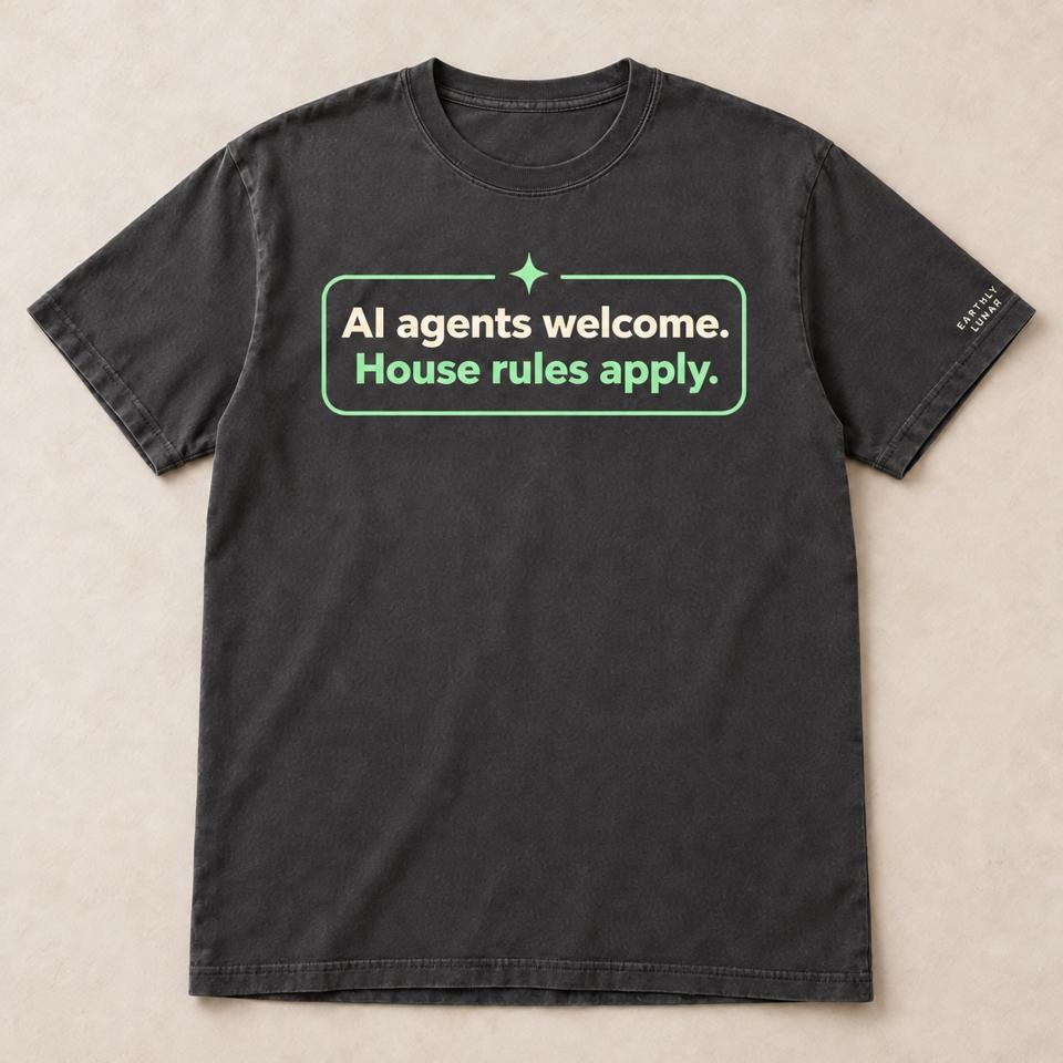 Charcoal tee with a mint-outlined badge reading 'AI agents welcome. House rules apply.' under a small sparkle