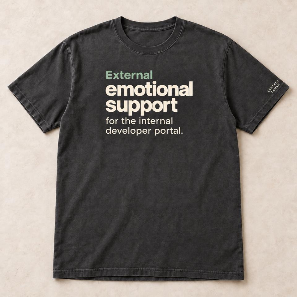 Charcoal tee with mint 'External', large cream 'emotional support', and smaller cream 'for the internal developer portal.'